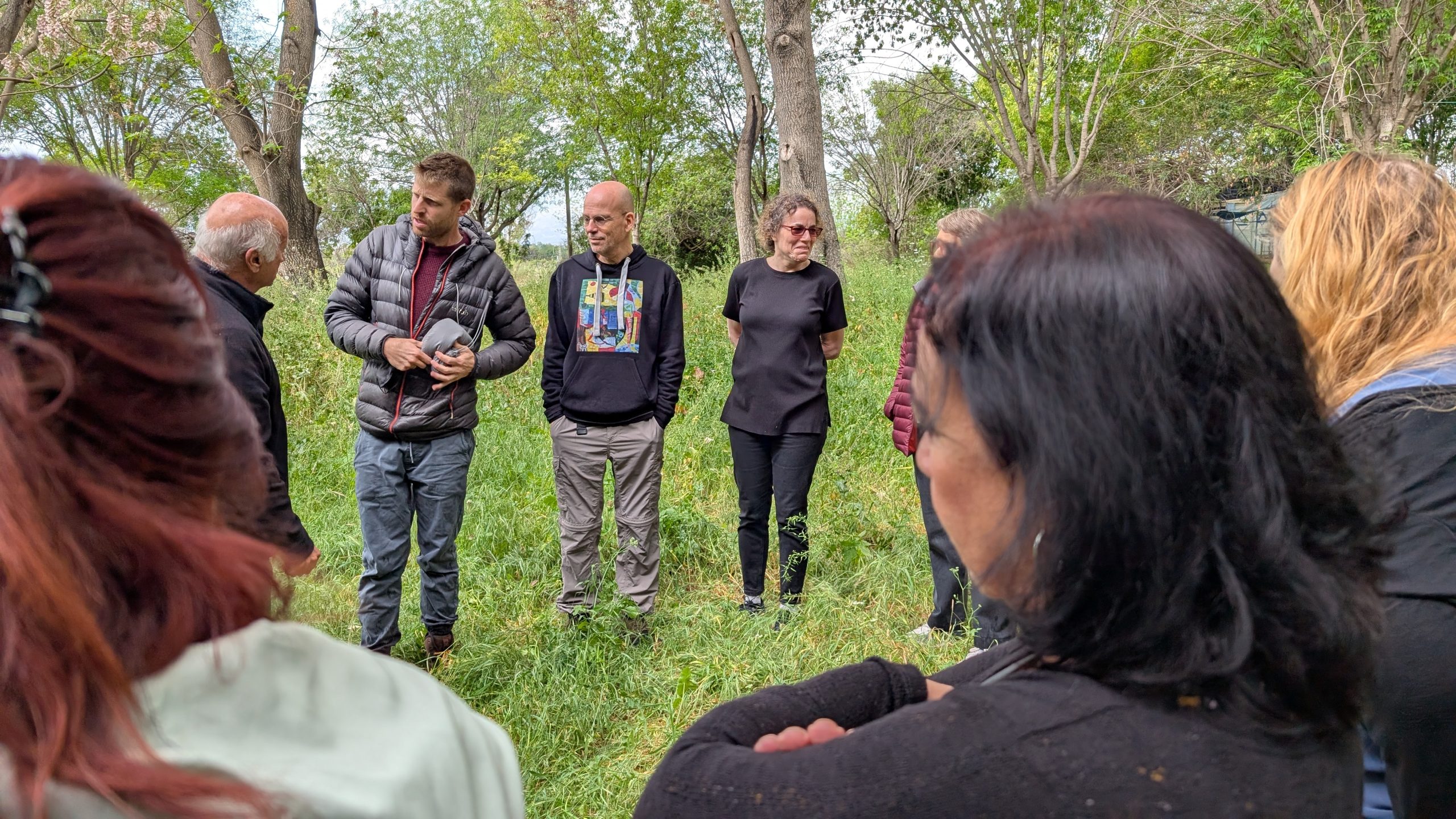 משתתפים עומדים בין העצים בפעילות ביער מרפא דפנה